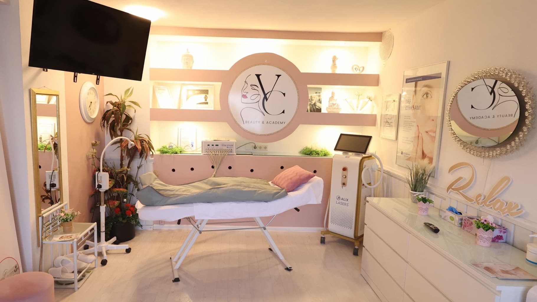 Heller Behandlungsraum mit Liege, rosa Regalwand und großem Vlera-Cosmetics-Logo